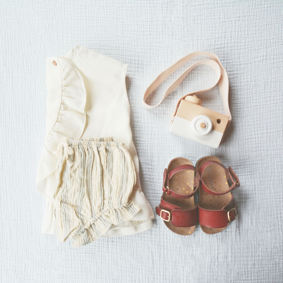 Romper, sandals and toy camera flat lay